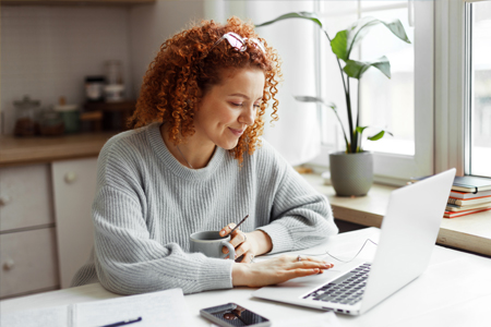 Woman smiling at computer whilst working