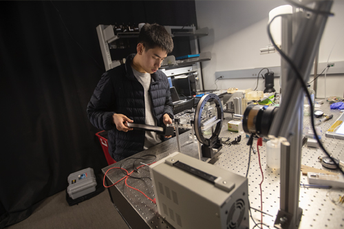 Physics student working in experimental optics lab