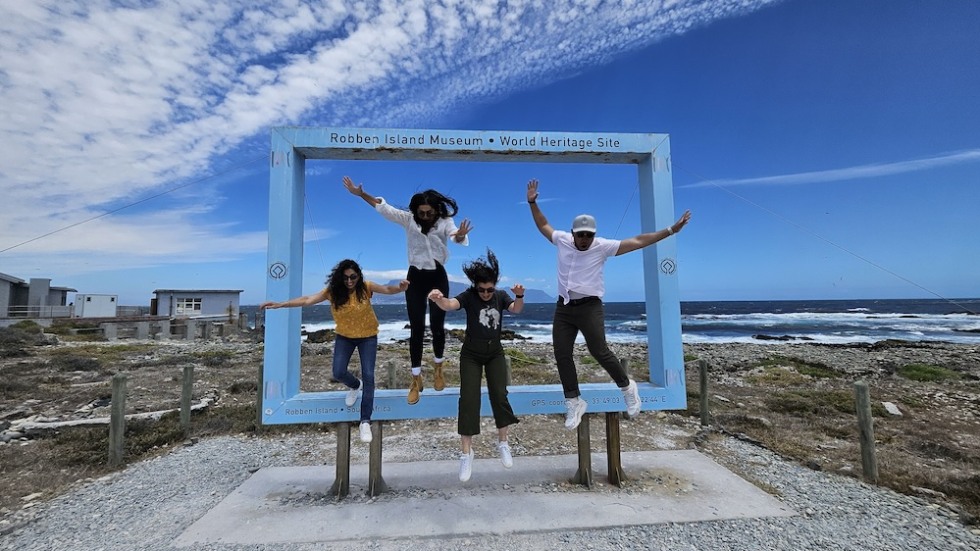 Students posed in front of the Robben Island Museum World Heritage Site sign, commemorating their visit to the historic landmark.