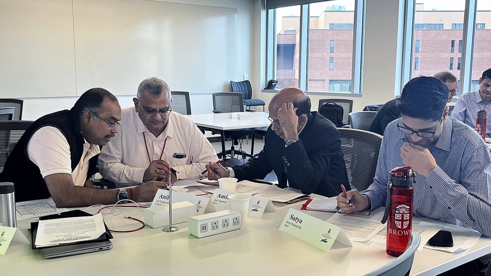 students huddled around work in a classroom