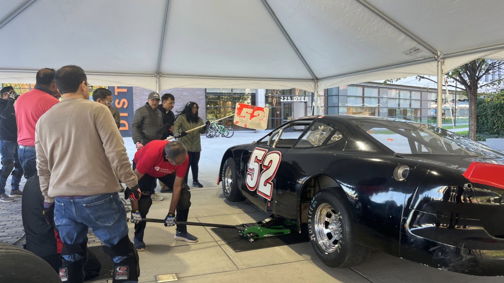 student participating in changing the tires in a pit crew style 