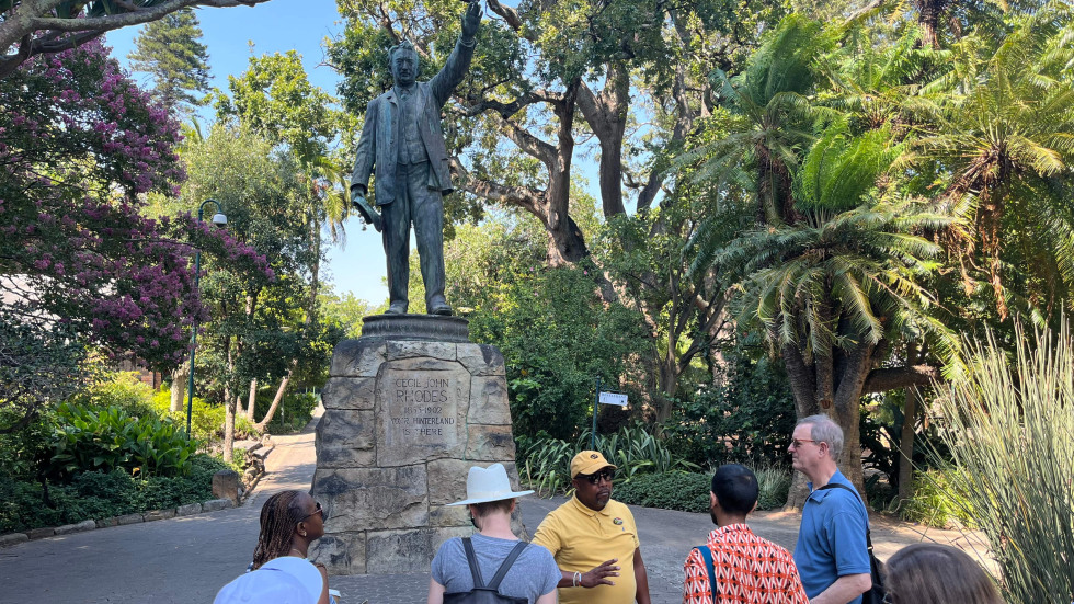 group photo of tour looking at a statue 