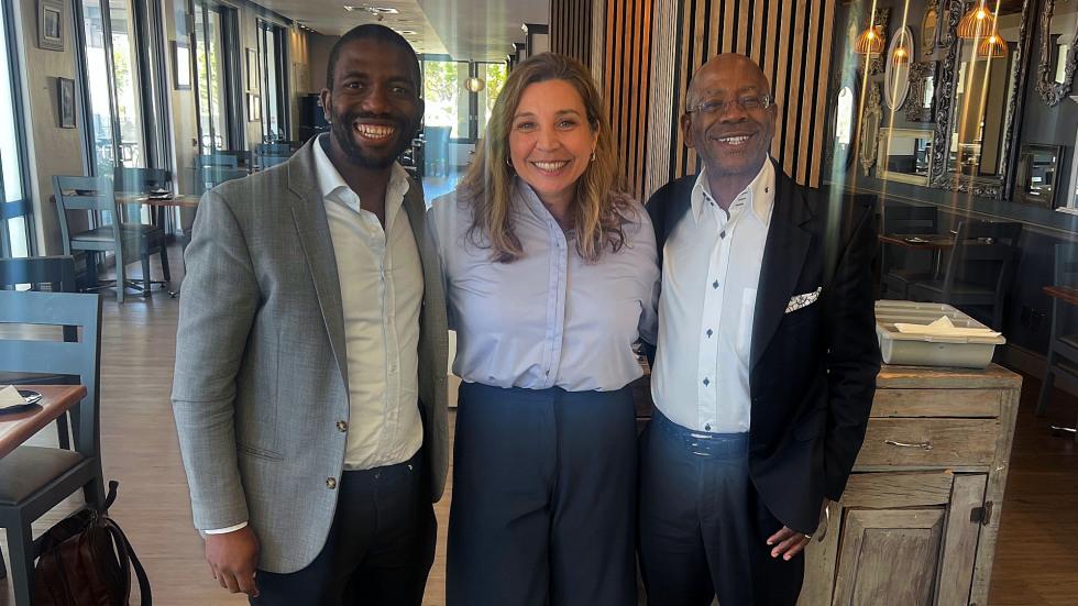 three people smiling for a group photo